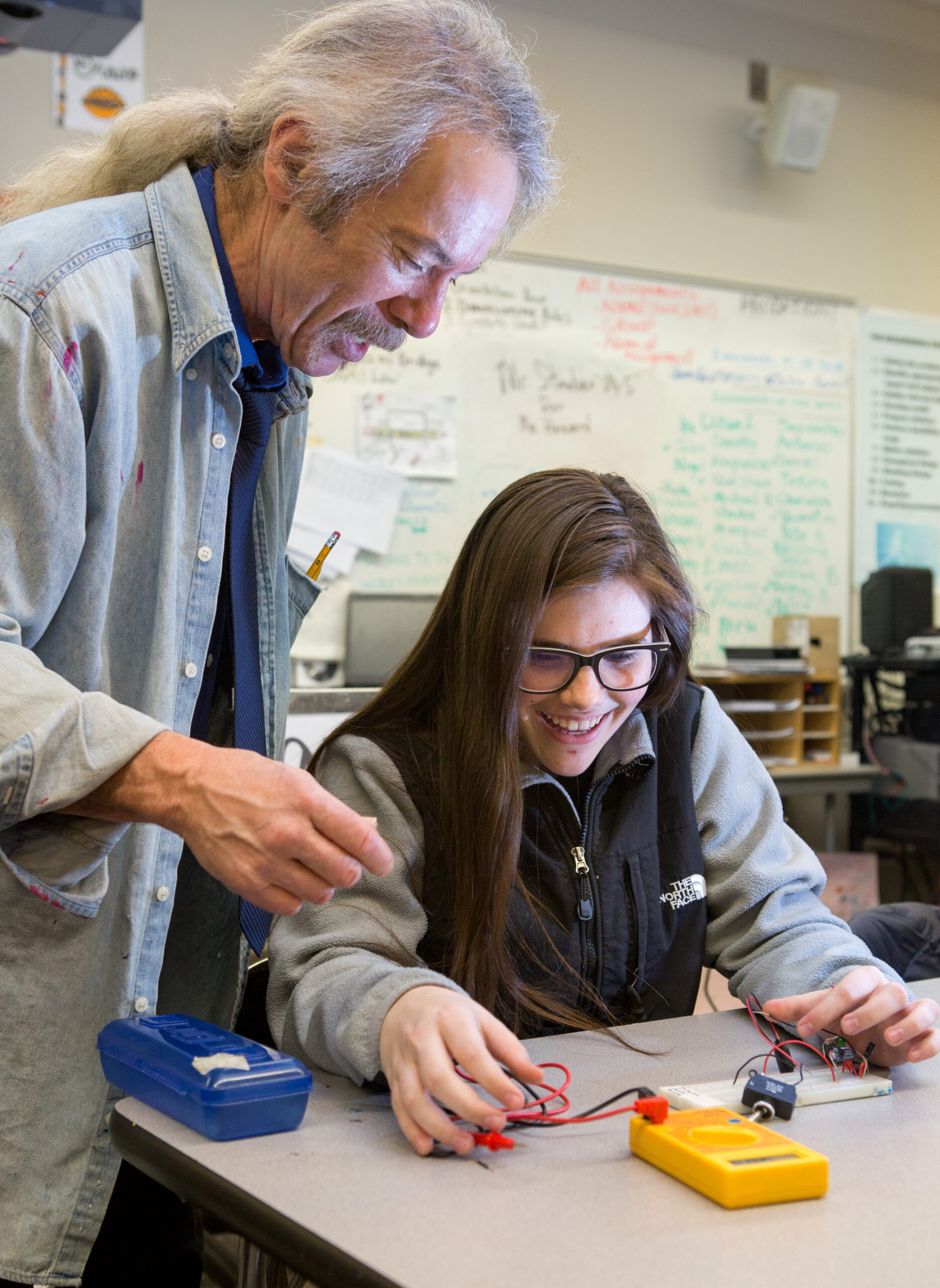 Male teacher helps a female ninth grader