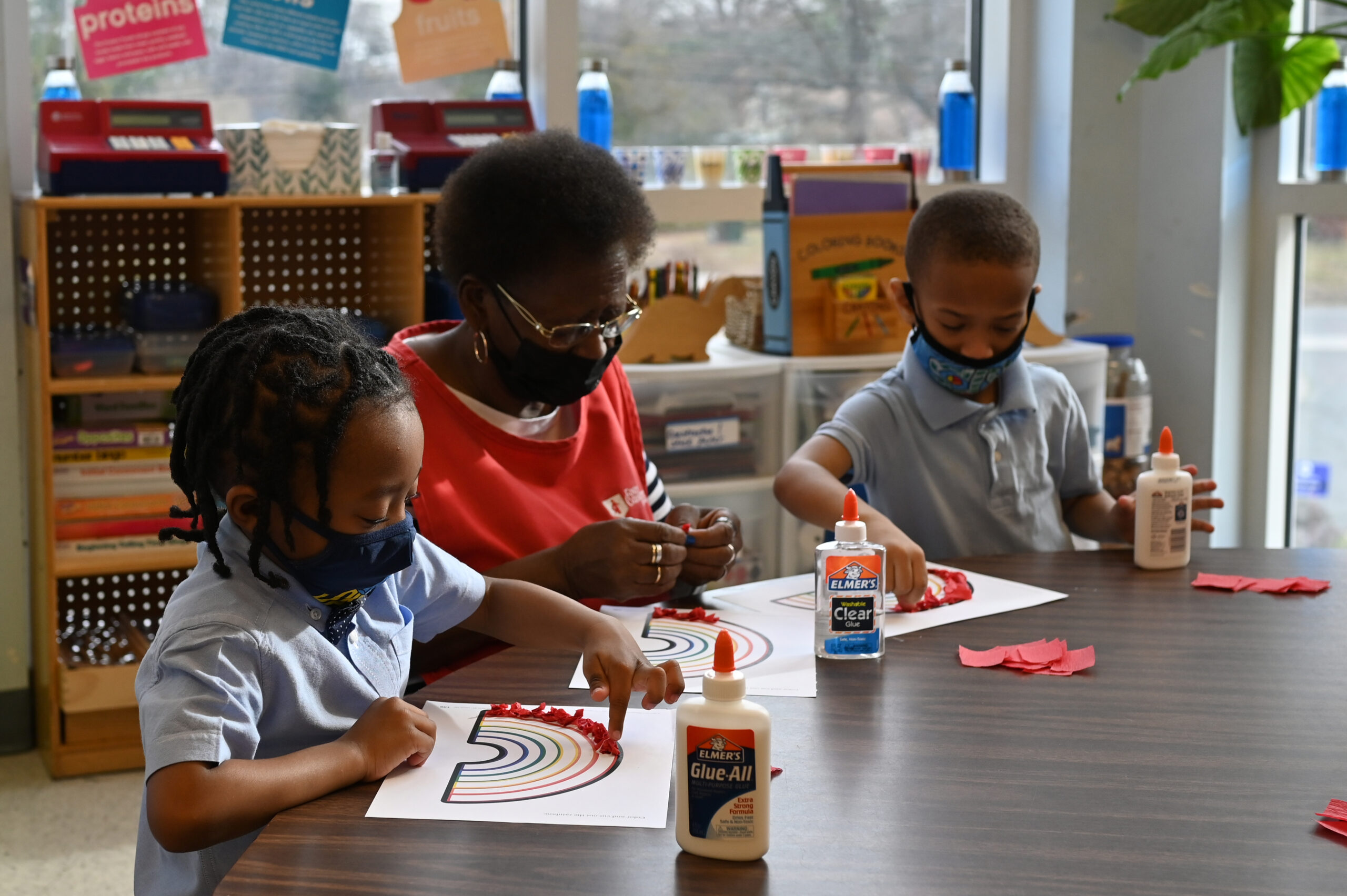 two students with a tutor in a classroom setting