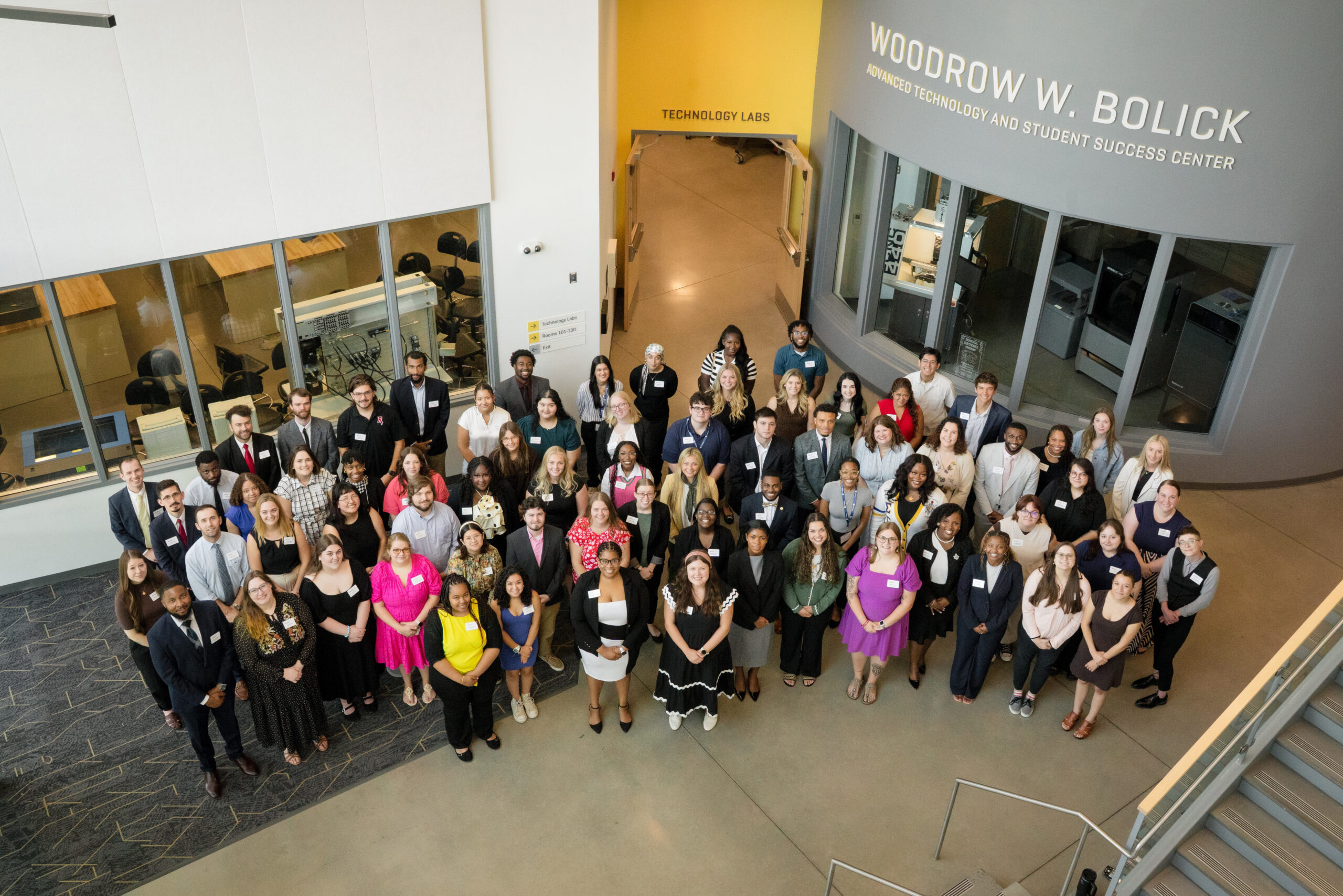 A photograph of a group of adults lookin up at the camera. This group includes AdviseVA advisers and program staff.