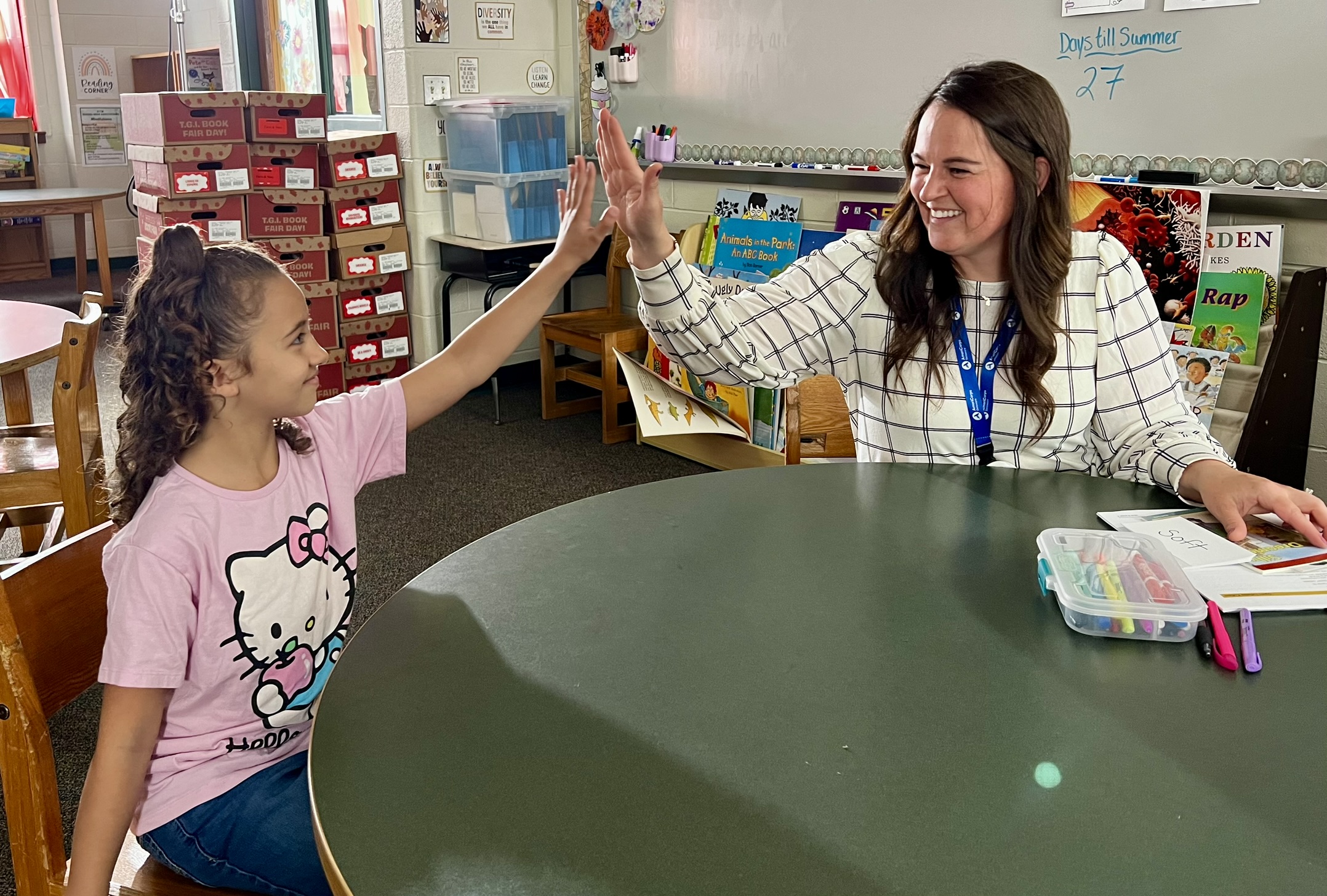 Image of an adult high-fiving a student.
